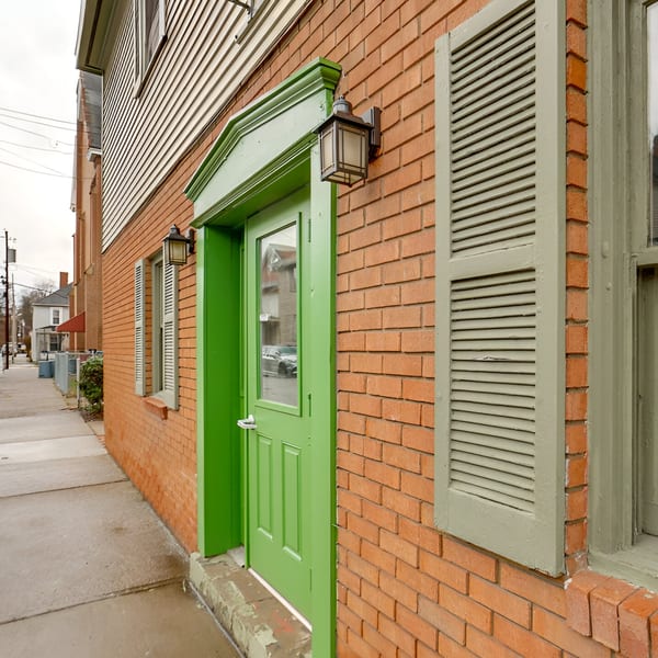 The brick exterior of Rockwell’s Red Lion Restaurant features a bright green door and shutters.