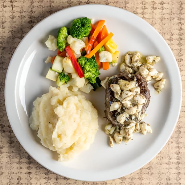 A Rockwell’s Red Lion Restaurant plate with steak, mashed potatoes, and mixed vegetables.